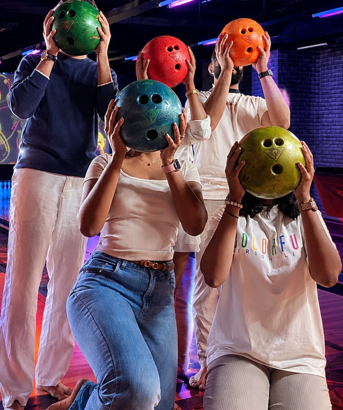 Team members holding bowling balls at a team night out